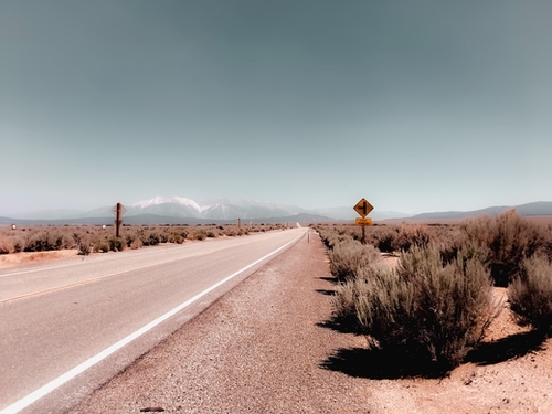 Road in the desert with blue sky and mountain view in California USA Mural by Timmy333