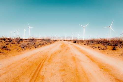 Wind turbine and sandy road desert with blue sky in California USA Mural by Timmy333